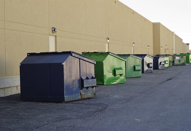 a construction worker moves construction materials near a dumpster in Bolton, MS